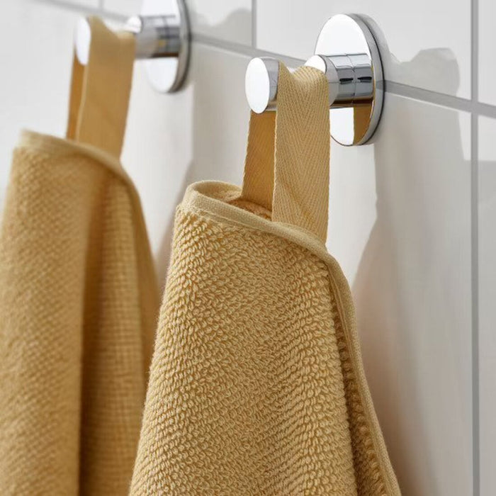 A close-up image of a folded Light yellow hand towel with a textured pattern 70508340 