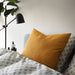 Multiple IKEA cushion covers in different colors and designs on a bed 60456544