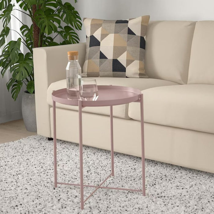 IKEA tray table, with a book, a cup of tea, and reading glasses on top. The clean lines and simple design make it a stylish addition to any room."
