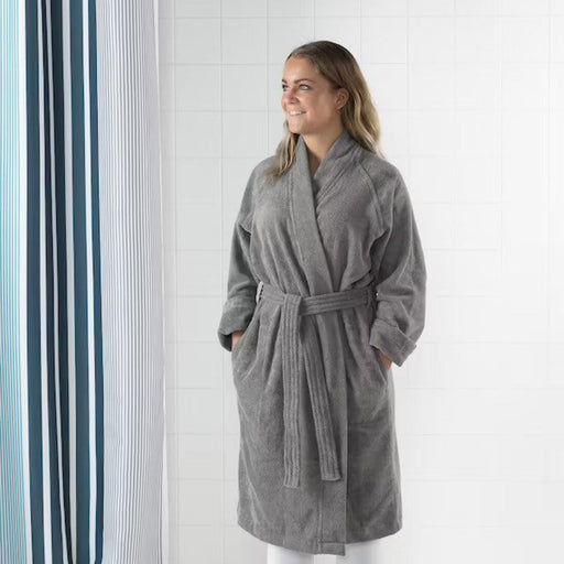 "Dark gray bathrobe with pockets and shawl collar, folded neatly on a shelf."