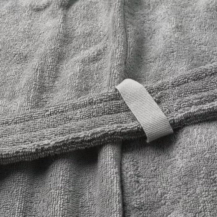 A gray bathrobe with a belt tie and two front pockets, hanging on a white hook.