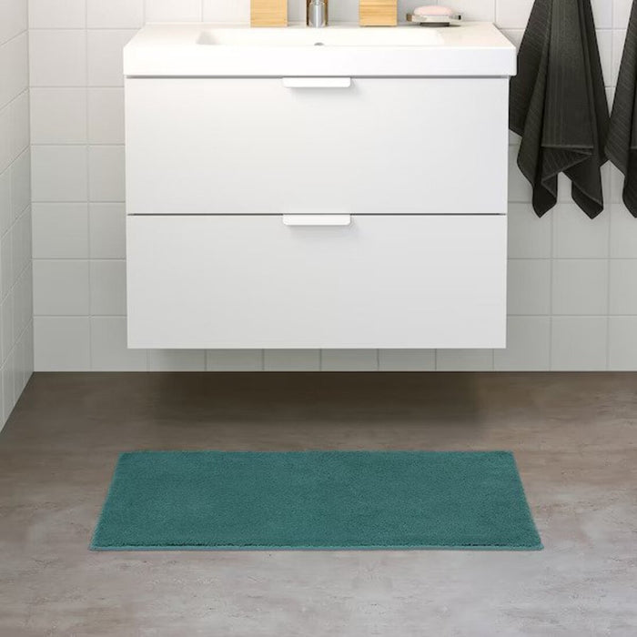 Grey-turqoise bath mat placed on a bathroom floor, featuring a soft and absorbent texture and a non-slip bottom for secure footing 90507995