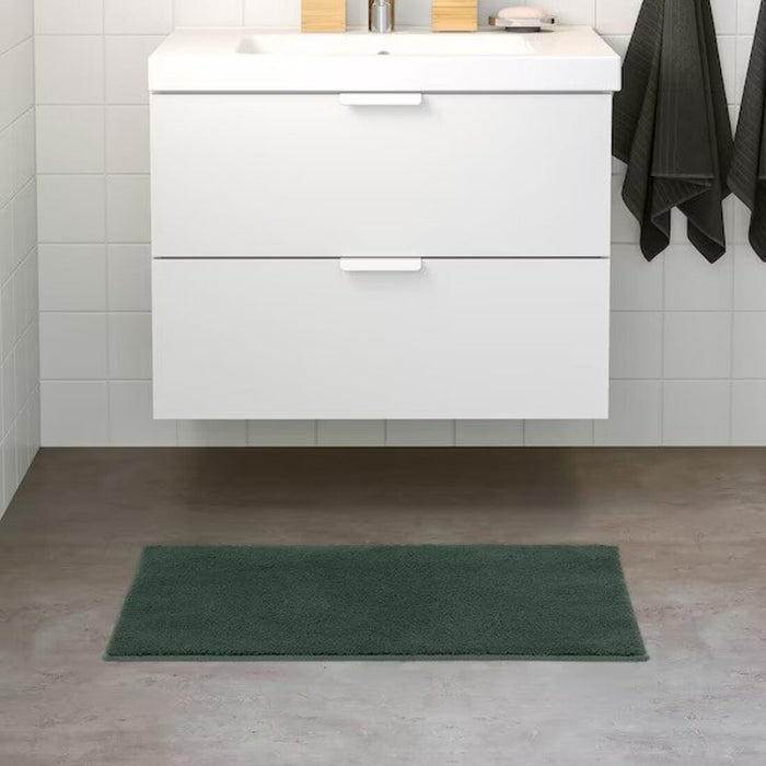 IKEA bath mat placed on a bathroom floor, featuring a soft and absorbent texture and a non-slip bottom for secure footing 60507992