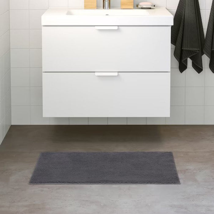 IKEA bath mat placed on a bathroom floor, featuring a soft and absorbent texture and a non-slip bottom for secure footing 20507989
