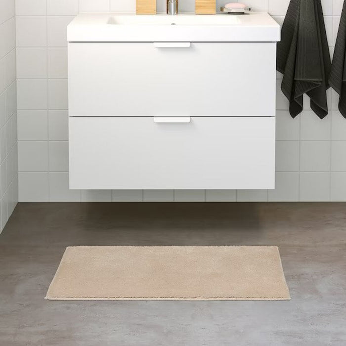 IKEA bath mat placed on a bathroom floor, featuring a soft and absorbent texture and a non-slip bottom for secure footing 50507978