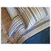 An closeup image of  beige/blue duvet cover with a striped pattern and matching pillowcases arranged on a bed  20443515