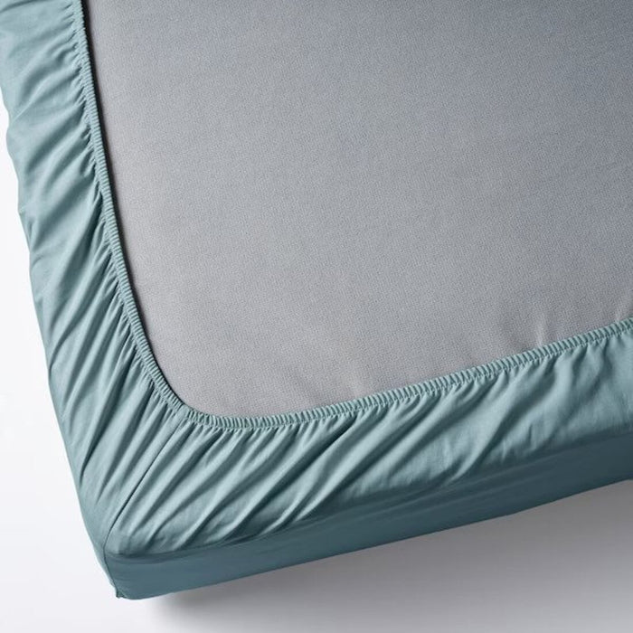 A close-up photo of an IKEA fitted sheet in blue with elastic edges to fit snugly over a mattress, 60501669