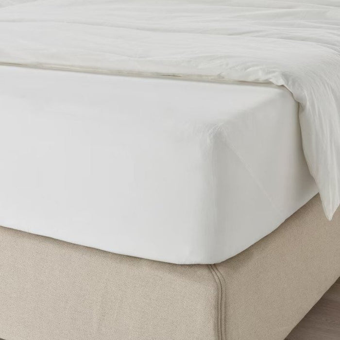 A closeup image of IKEA fitted sheet on a bed with neatly tucked corners and a smooth surface  10357221