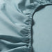 A close-up of an IKEA fitted sheet's elastic edges shows its stretchiness and durability.-00501672