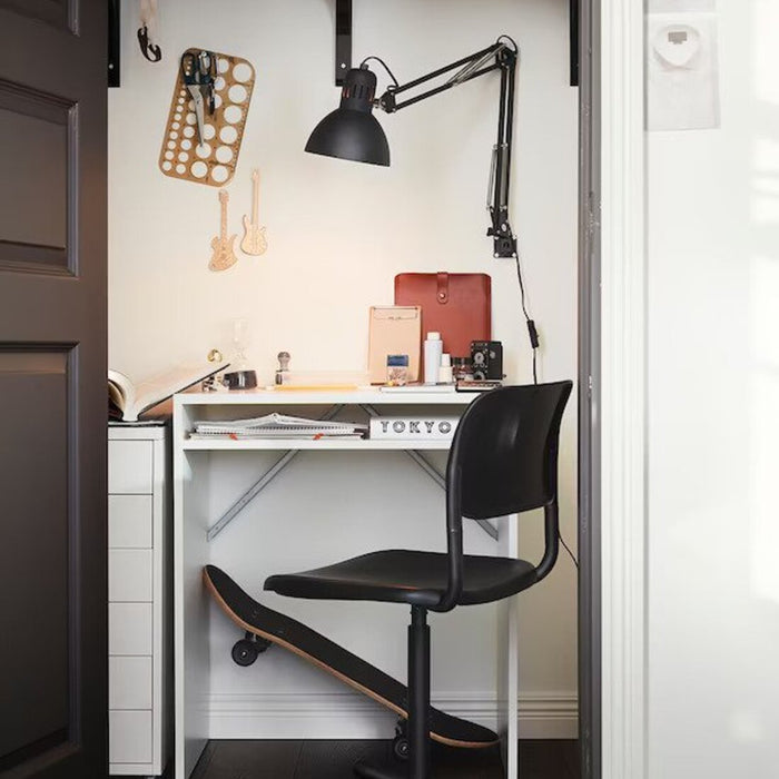 A white desk with shelves, a lamp, and a chair.