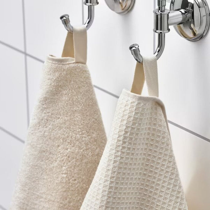 A close-up image of a folded natural  hand towel with a textured pattern and simple, classic hand towel, perfect for every bathroom 90512510