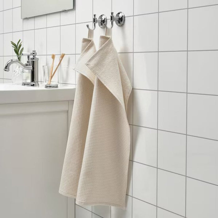 An image of an IKEA hand towel in a natural and white striped pattern, adding a classic and timeless touch to any bathroom. 90512510