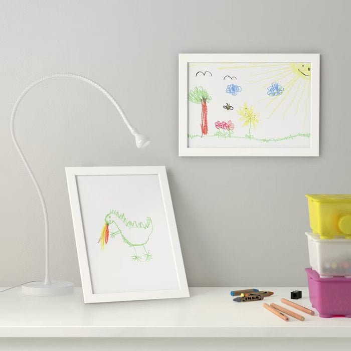 A white IKEA Tolsby frame, made of plastic and designed for displaying photos or messages on a desk or table 90300457