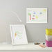 A white IKEA Tolsby frame, made of plastic and designed for displaying photos or messages on a desk or table 90300457