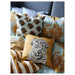 Multiple IKEA cushion covers in different colors and designs on a bed-10542988