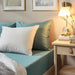 An IKEA fitted sheet in a soft, Grey-Turquoise on  bed-00486577