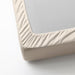 A close-up of an IKEA fitted sheet's elastic edges, showing its stretchiness and durability  30357164 