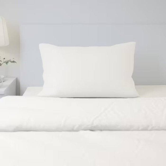 A white cotton pillowcase from IKEA lying on a bed adding a touch of elegance to the bedding  30347702