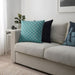 Multiple IKEA cushion covers in different colors and designs on a sofa -10504830