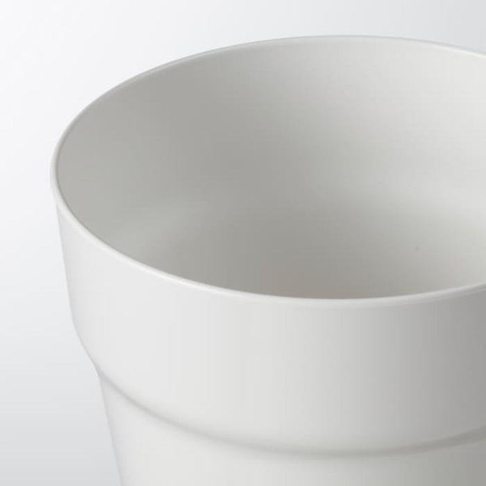 A white IKEA plant pot with a green plant inside