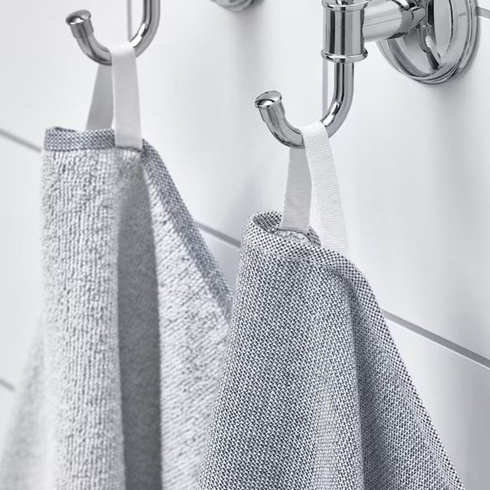A close-up image of a simple and classic white/blue hand towel hanging on a bathroom hook80521671 