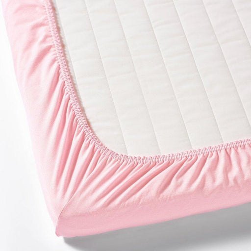 IKEA LEN pink fitted sheet close-up showing elastic corners secured on cot mattress