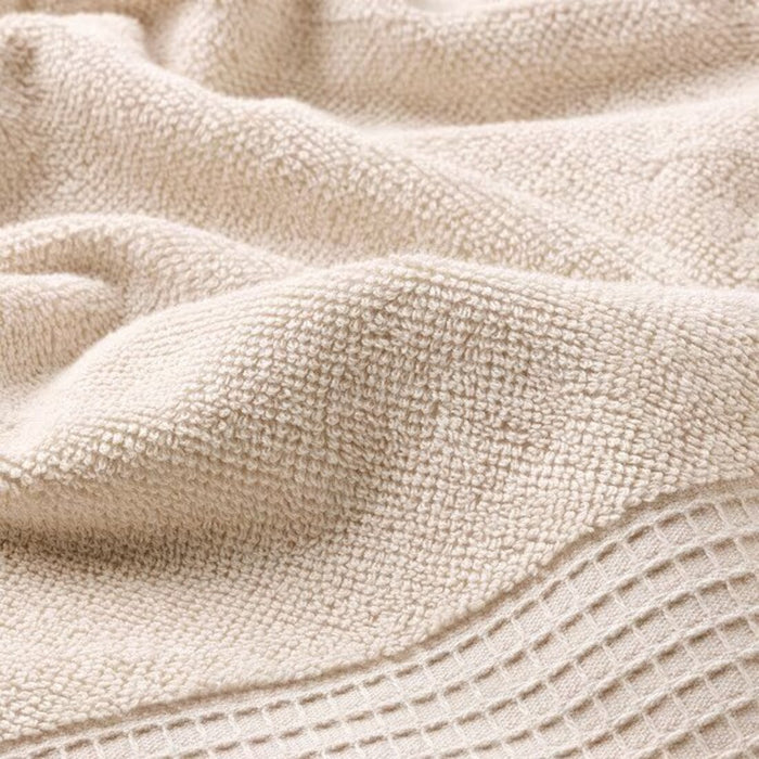 A close-up of a Light Grey/Beige  washcloth made of soft cotton fibers.
