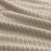 A close-up image of a folded light beige hand towel with a textured pattern 40494617