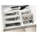 IKEA cutlery tray: "A white plastic tray with multiple compartments, designed to organize cutlery in a kitchen drawer.