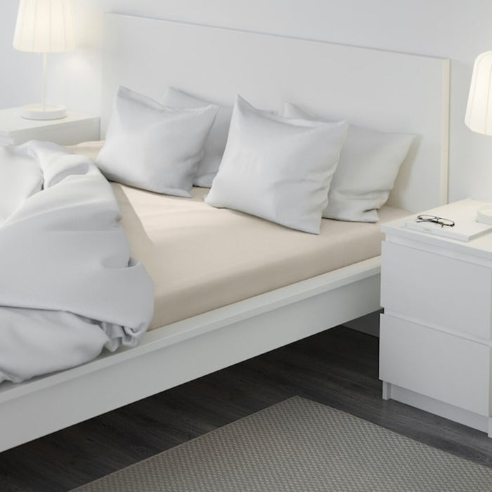 A beige IKEA fitted sheet on a bed with neatly tucked corners and a smooth surface-50357224