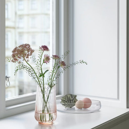 A decorative vase made of clear acrylic, featuring a wavy design and suitable for indoor or outdoor use.