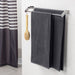 A pair of neatly folded Dark Grey bath towels hanging from a towel bar in a modern bathroom.
