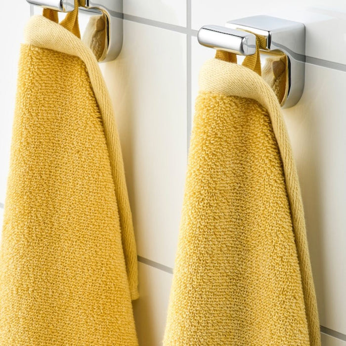 A close-up image of a folded yellow hand towel with a textured pattern 70442882