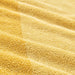 A close-up image of a yellow IKEA hand towel folded neatly with a soft texture 70442882