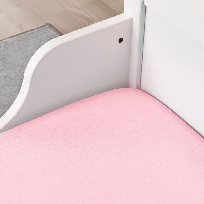 A pink IKEA fitted sheet on a bed with neatly tucked corners and a smooth surface. 40465295