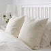 Multiple IKEA cushion covers in different colors and designs on a bed -40456540