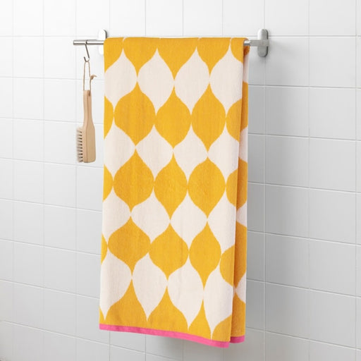 A bath towel hanging on a hook on the back of a bathroom door