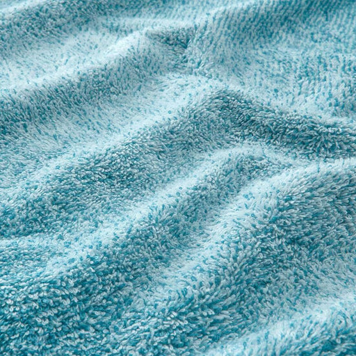 A close-up image of a folded white/turquoise hand towel with a textured pattern 20494388