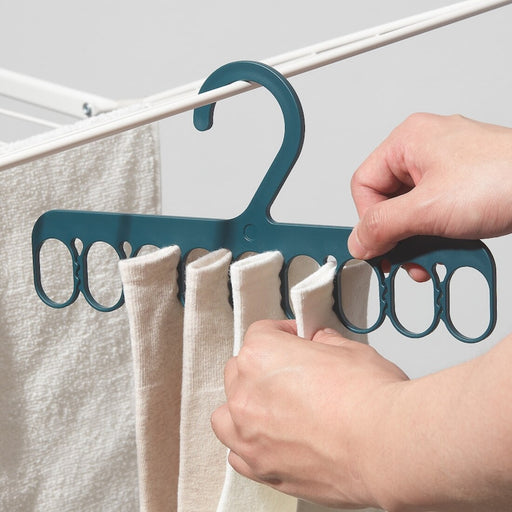 An accessories close-up of the IKEA Hanger with 8 Grip Clips, highlighting its versatility in hanging a range of items such as scarves, belts, and hats.