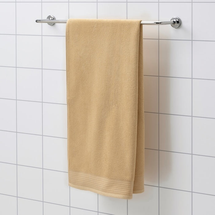 An absorbent light yellow towel, measuring 70x140 cm, hanging from a hook in a bathroom.40508332