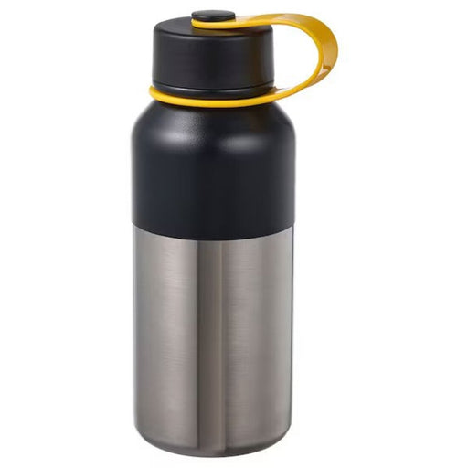 A backpacker holding a vacuum flask while hiking in the forest. 30521051                                   