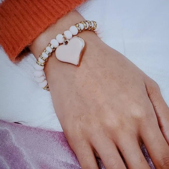 "A braided friendship bracelet with a heart-shaped charm"