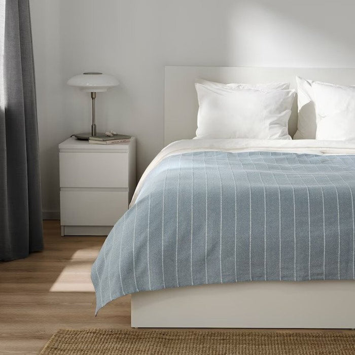 A soft and comfortable IKEA bedspread in a rich color, measuring 230x250 cm, draped over a bed.