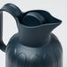 A close-up of the vacuum flask's black lid and handle, showing its smooth and ergonomic design.