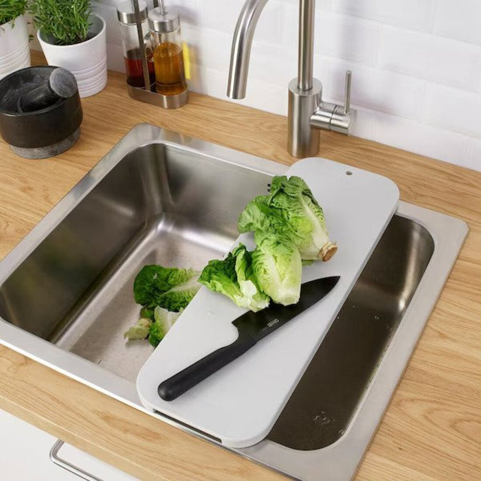 A light grey chopping board from IKEA, measuring 48x17 cm, with a knife and vegetables on top 20512801 