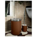 Brown toilet brush: A brown toilet brush with a holder to keep it upright when not in use, made from sturdy materials.