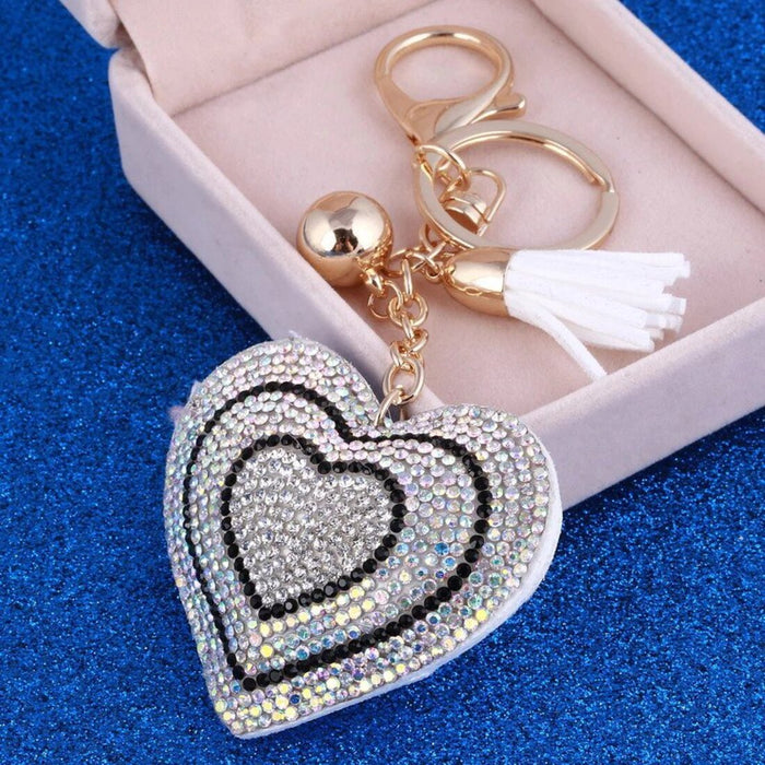 A heart-shaped key chain with a crystal charm in shades of multicolor and black