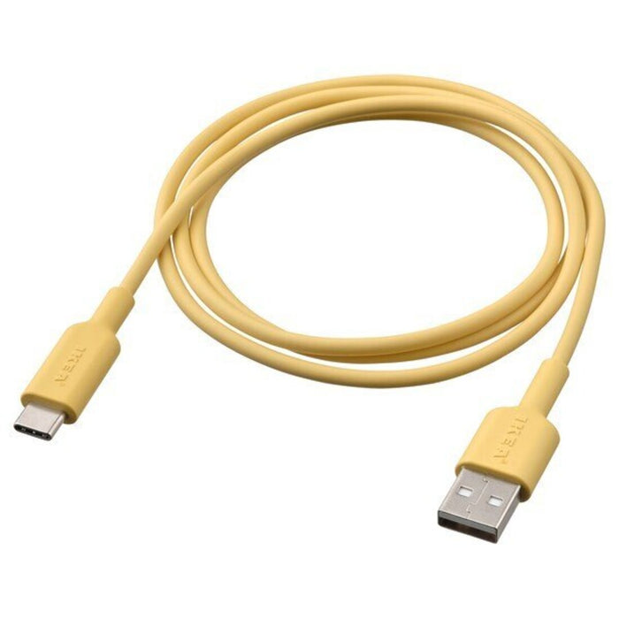 A coiled-up light yellow USB-A to USB-C cable resting on a white surface."-90539487                      