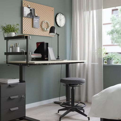 A photo of a compact IKEA Black desktop shelf with a lamp, office supplies, and a notebook, maximizing desk space in a home office 60541571