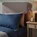 A blue cotton pillowcase from IKEA lying on a bed adding a touch of elegance to the bedding  30337029